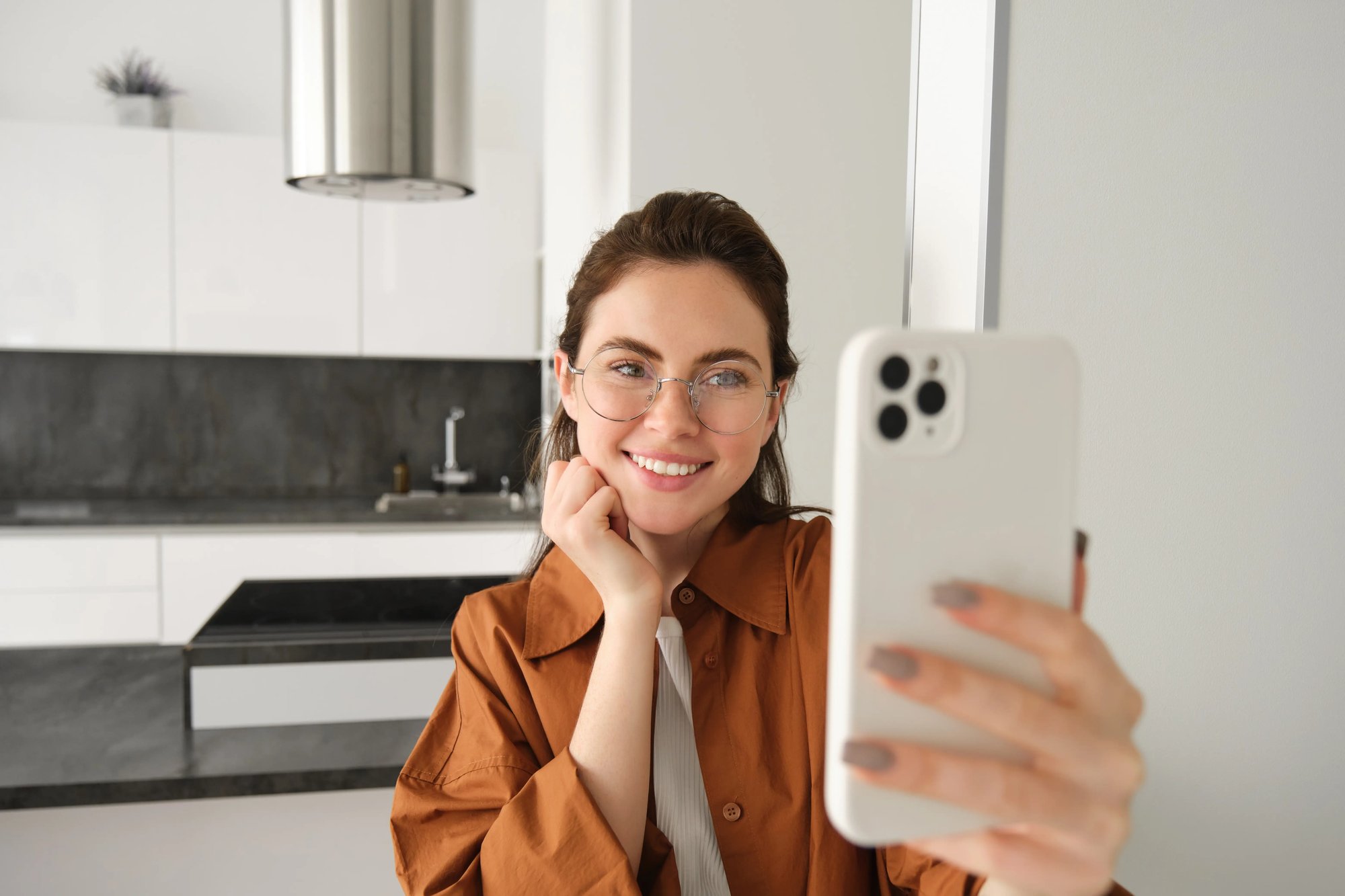 beautiful-young-woman-glasses-taking-selfie-her-flat-using-smartphone-posing-photo